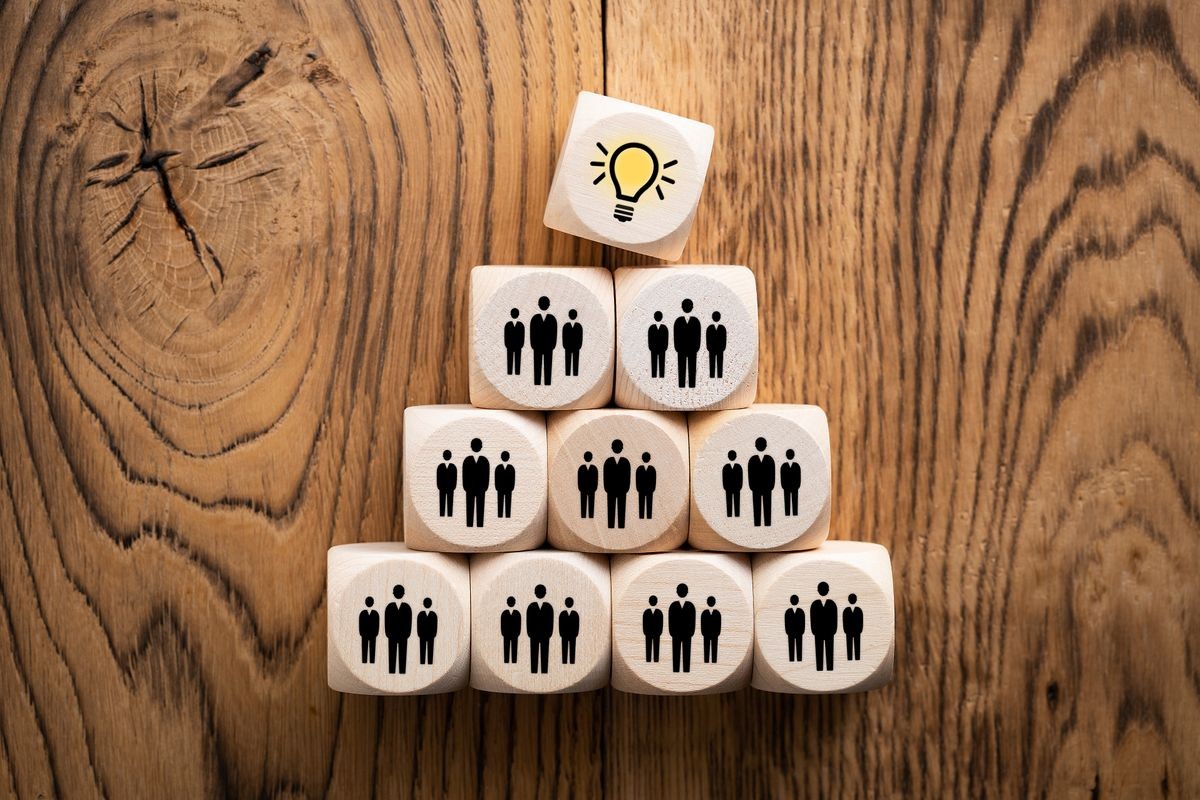 many people together having an idea symbolized by icons on cubes many people together having an idea symbolized by icons on cubes